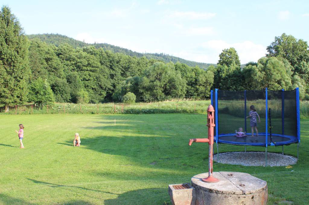 Zahrada s trampolínou a výhledem na zalesněné kopce